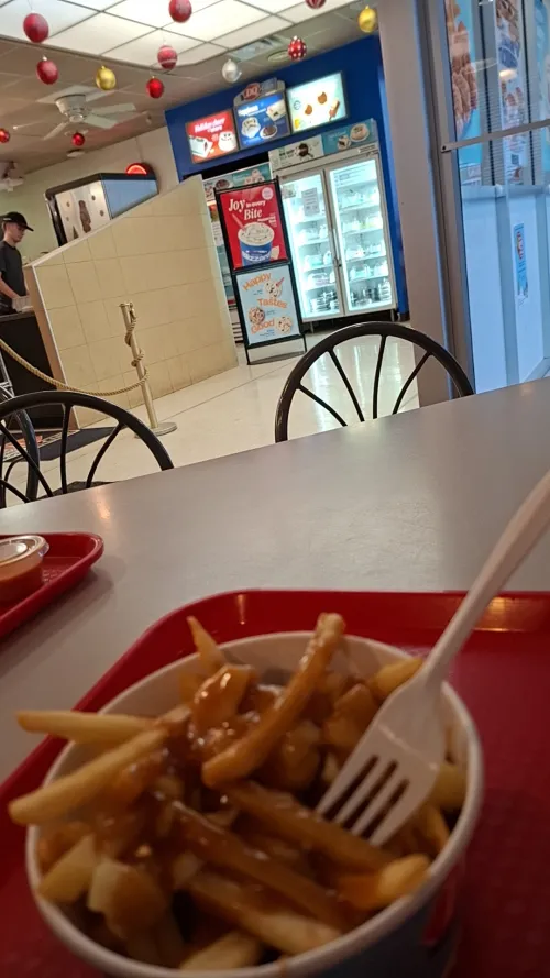 Fries with gravy on a red tray in a dairy queen.