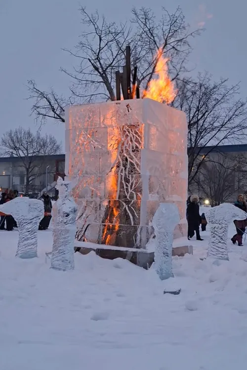 Tall cubic tower of ice with a big fire within and ice statues around